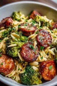 Chicken sausage broccoli orzo in a large pot with Parmesan cheese and fresh parsley