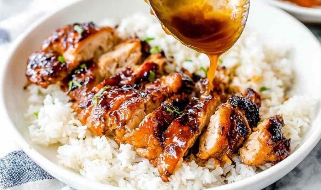 Easy chicken teriyaki sliced and glazed with homemade teriyaki sauce served over steamed white rice with sesame seeds