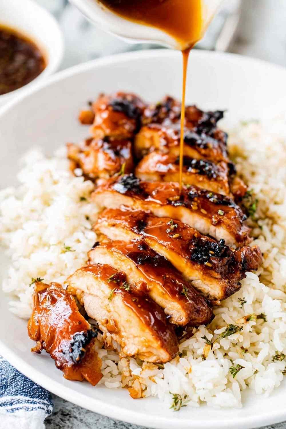 Easy chicken teriyaki sliced and glazed with homemade teriyaki sauce served over steamed white rice with sesame seeds