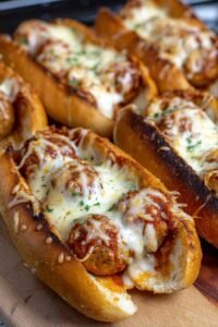 Easy weeknight chicken meatball subs on a baking sheet with bubbling mozzarella and marinara sauce fresh from the broiler
