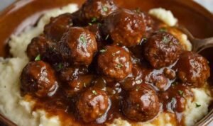 Slow Cooker Salisbury Chicken Meatballs in a crockpot with thick savory onion-brown gravy and fresh parsley garnish