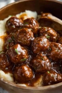 Slow Cooker Salisbury Chicken Meatballs in a crockpot with thick savory onion-brown gravy and fresh parsley garnish