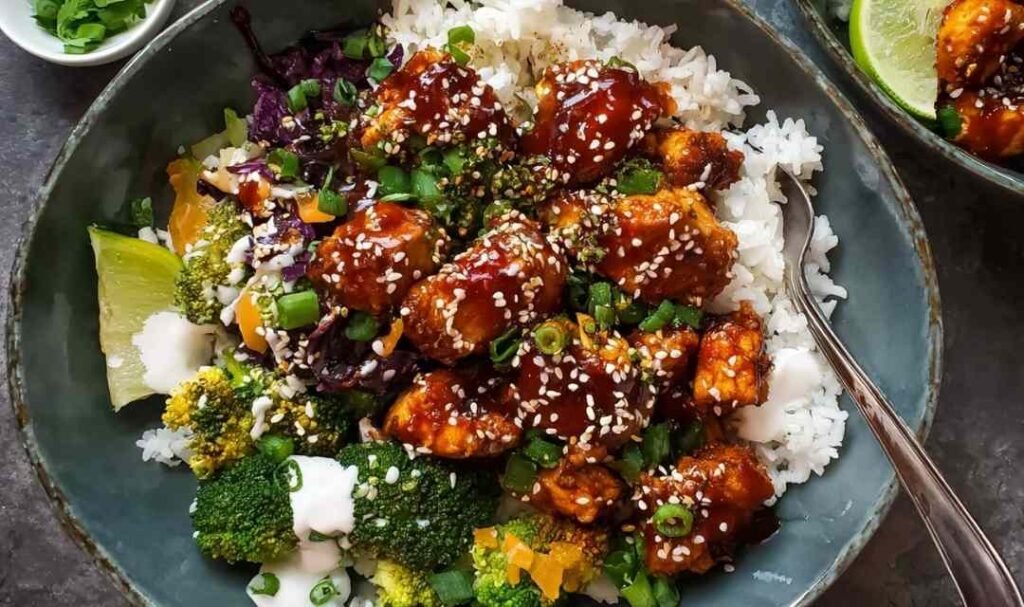 sticky chicken bowls with glazed chicken rice broccoli and spicy mayo drizzle topped with sesame seeds
