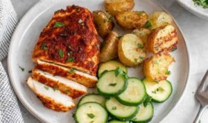 Juicy sliced air fryer chicken breast on a white plate with a golden spice crust