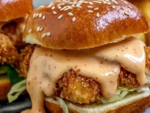 Bang Bang Chicken Sliders with creamy spicy sauce, fresh lettuce, and tomato on fluffy mini buns