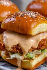 Bang Bang Chicken Sliders with creamy spicy sauce, fresh lettuce, and tomato on fluffy mini buns