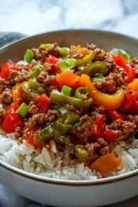 Beef pepper rice bowl in a large skillet with seasoned ground beef, colorful bell peppers, and jasmine rice