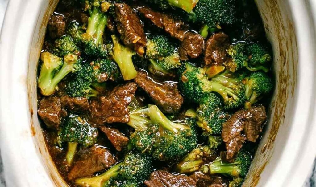 Beef and broccoli stir fry in a cast iron skillet with thick savory sauce and sesame seed garnish
