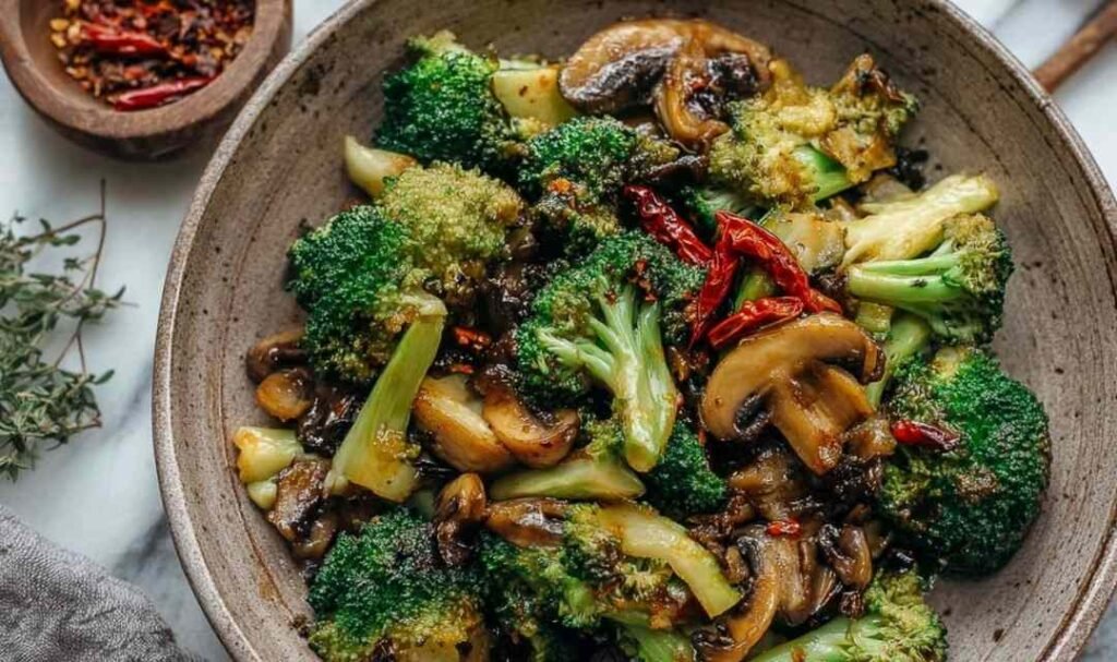 Broccoli and mushroom stir fry in a wok with glossy savory sauce and golden seared mushrooms