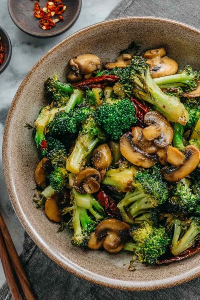 Broccoli and mushroom stir fry in a wok with glossy savory sauce and golden seared mushrooms