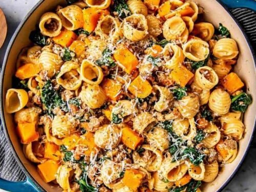 Skillet of butternut squash pasta with Italian sausage, spinach, and Parmesan