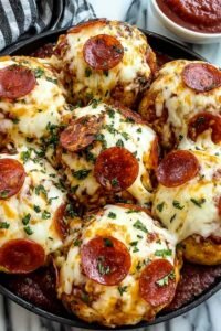 Golden cheesy pepperoni pizza bombs on a parchment-lined baking sheet fresh from the oven