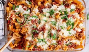 Baked Ziti in a 13x9 baking dish fresh from the oven with golden brown melted mozzarella and Parmesan on top