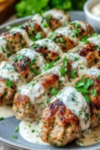 Chicken kofta with garlic yogurt sauce on a white serving platter with fresh parsley and warm pita bread