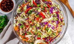 Chinese Chicken Salad A large bowl of Chinese chicken salad with shredded chicken, red cabbage, carrots, and sesame ginger dressing