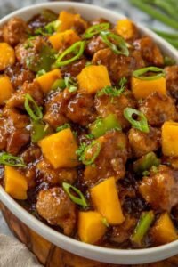 Chinese Style Mango Chicken Stir Fry with crispy golden chicken and mango in glossy savory-sweet sauce in a wok