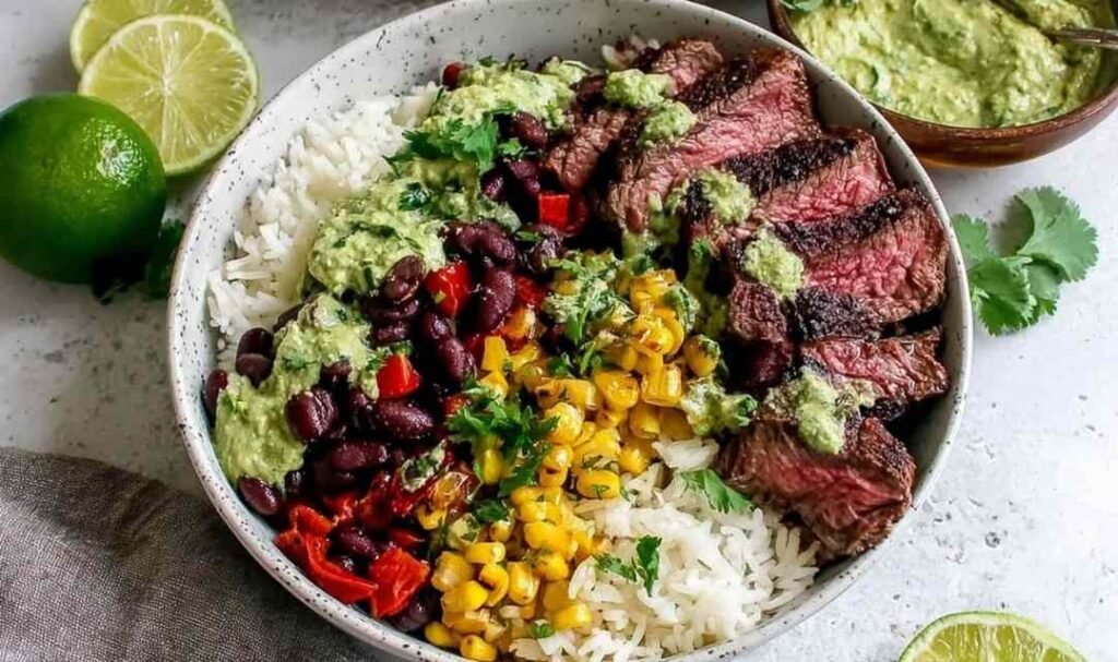 Cilantro lime steak bowl with sliced grilled flank steak, avocado, black beans, corn, and cherry tomatoes over white rice