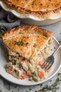 Unbaked turkey pot pie with crimped homemade butter crust in a deep dish pie pan ready for the oven at 425 degrees