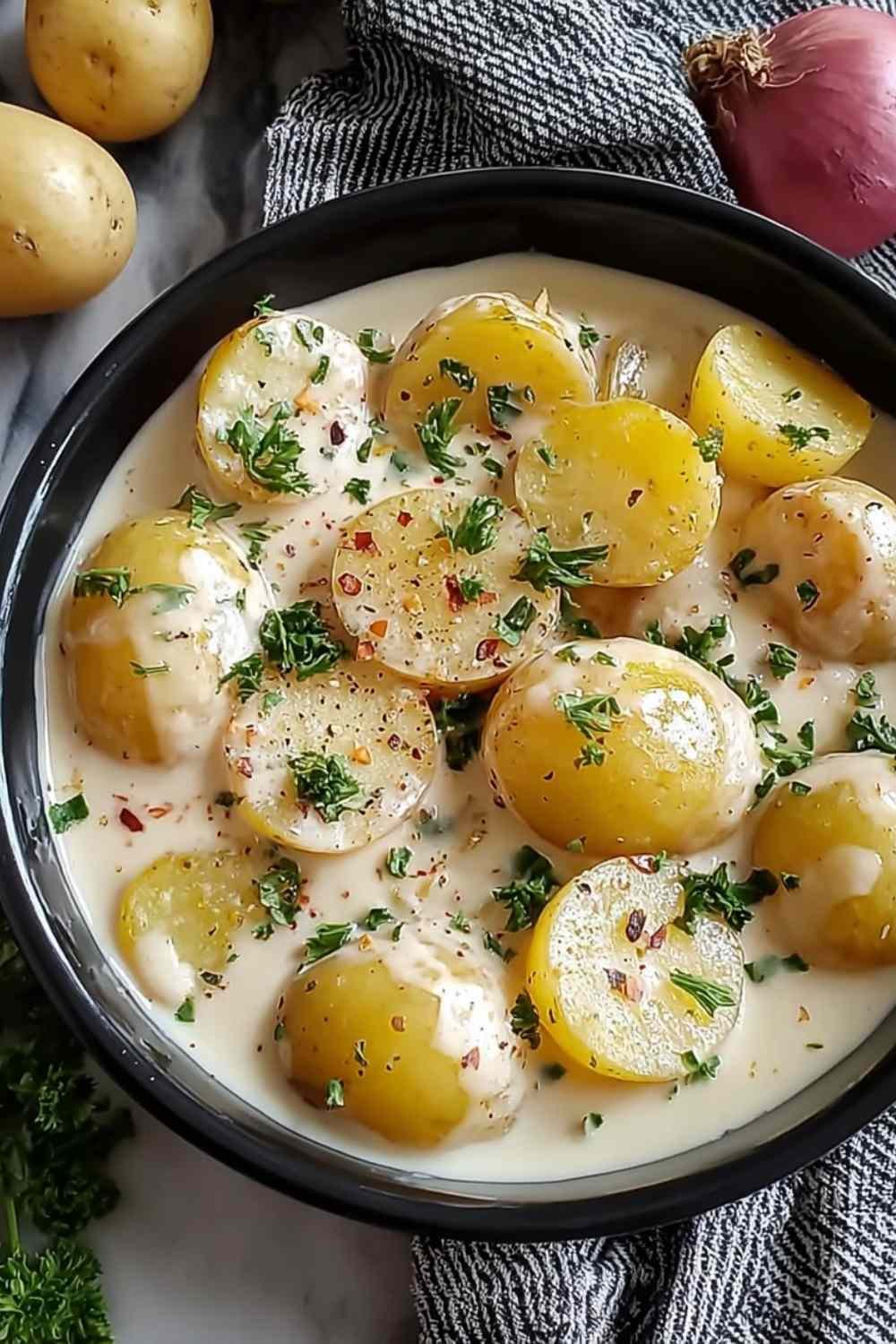 Creamy garlic sauce potatoes in a serving bowl with velvety garlic cream sauce, melted Parmesan, and fresh parsley garnish