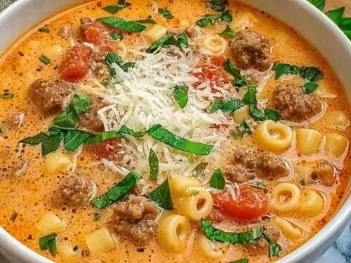 Creamy Parmesan Italian beef sausage soup in a white bowl topped with freshly grated Parmesan and chopped parsley showing the rich silky broth