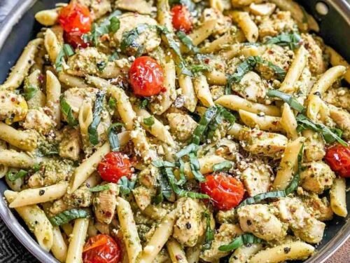 Easy chicken pesto pasta with cherry tomatoes and spinach tossed in a skillet with basil pesto