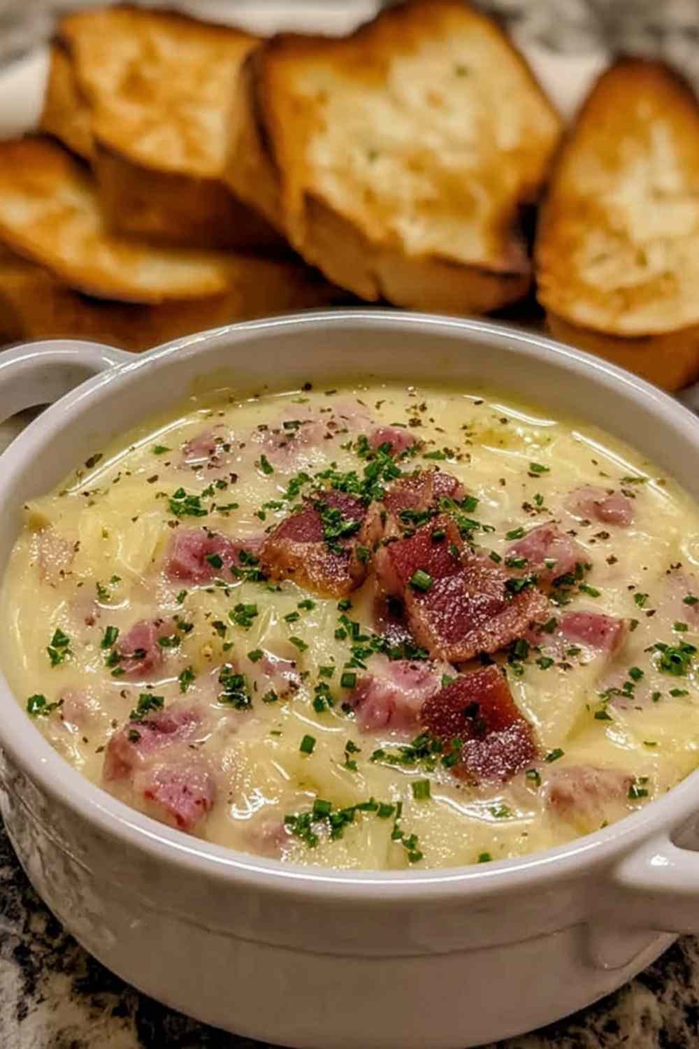 A bowl of creamy Reuben soup topped with rye bread croutons and fresh parsley, served as a comforting weeknight dinner