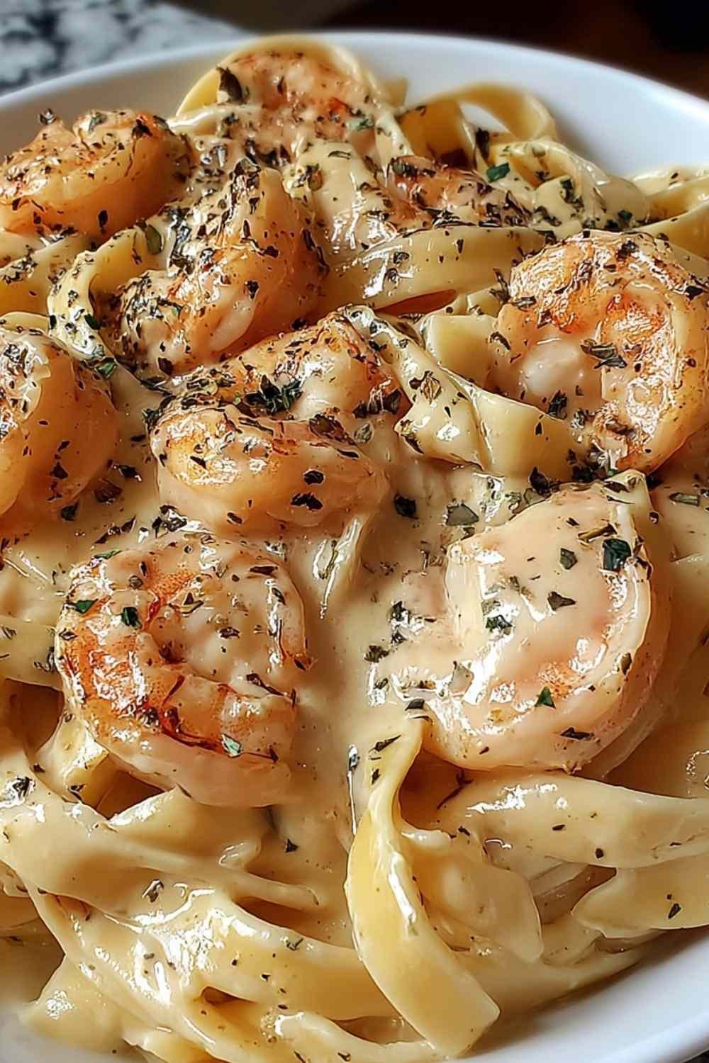 Creamy shrimp fettuccine Alfredo in a large skillet garnished with fresh parsley and Parmesan