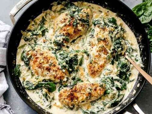 Creamy spinach chicken in a skillet with golden chicken cutlets and wilted spinach in garlic cream sauce
