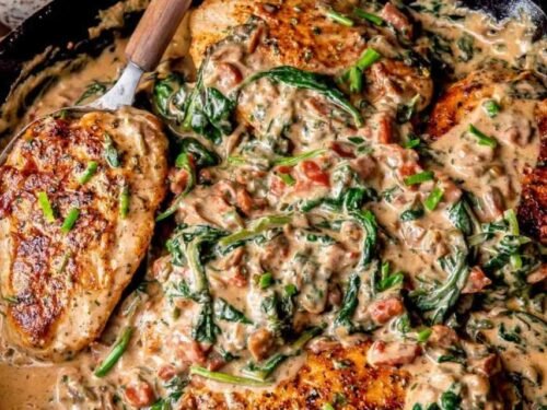 Creamy Tuscan chicken with sun-dried tomatoes and spinach in a cast iron skillet