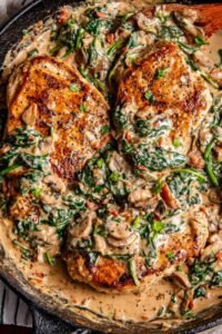 Creamy Tuscan chicken with sun-dried tomatoes and spinach in a cast iron skillet