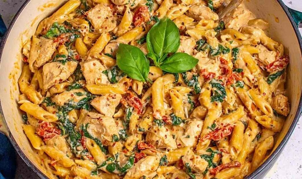 One pot tuscan chicken pasta with sun-dried tomatoes, spinach, and creamy Parmesan sauce in a large deep skillet
