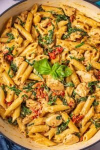 One pot tuscan chicken pasta with sun-dried tomatoes, spinach, and creamy Parmesan sauce in a large deep skillet