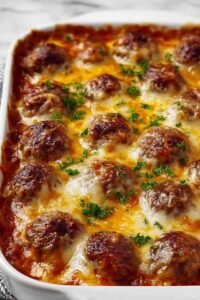 Dump-and-bake meatball casserole with golden melted cheese and marinara sauce in a 9x13 baking dish
