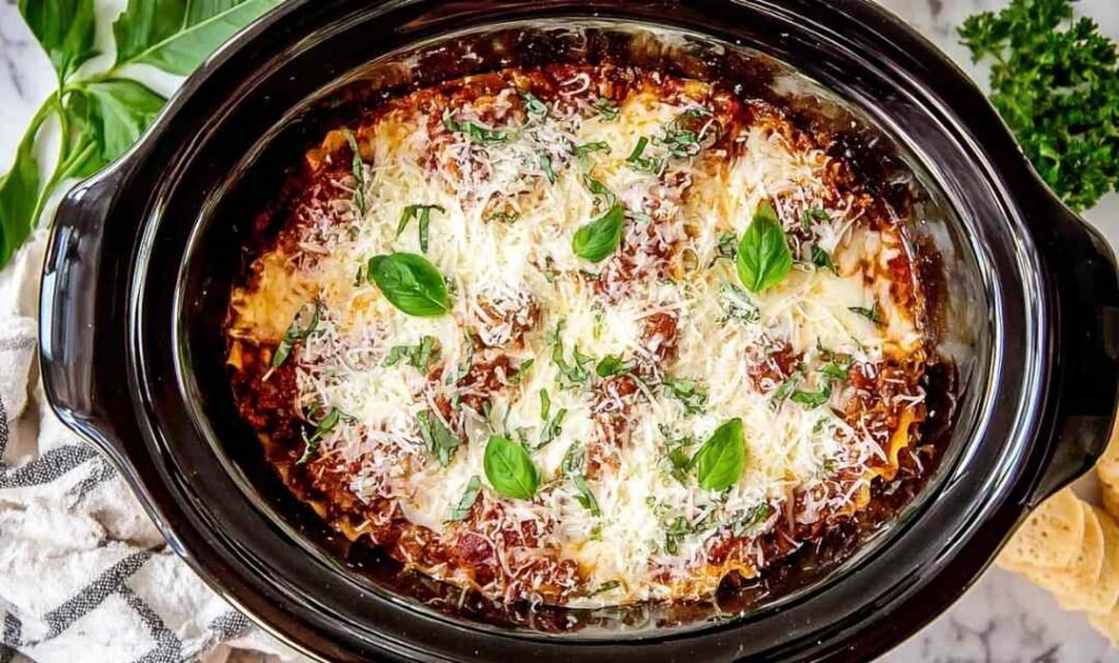 Easy crockpot lasagna with cheesy layers and marinara sauce cooking in a slow cooker