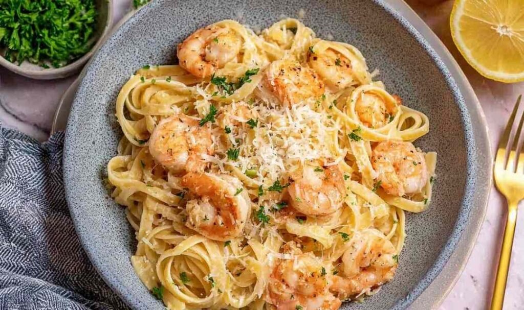 Easy shrimp pasta in a large skillet with garlic butter sauce, lemon zest, Parmesan, and fresh parsley