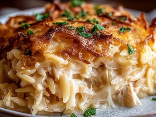 Golden bubbly French Onion Chicken Orzo Casserole fresh from the oven in a cast iron skillet
