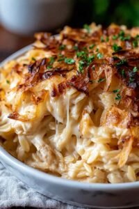 Golden bubbly French Onion Chicken Orzo Casserole fresh from the oven in a cast iron skillet