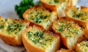 Easy Garlic Bread with Sliced Bread Crispy garlic bread with sliced bread on a baking sheet with golden buttery edges and fresh parsley