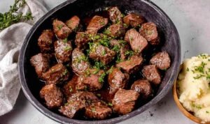 Easy Steak Tips with Garlic Soy Marinade Juicy steak tips searing in a cast iron skillet with a golden brown crust and garlic soy marinade