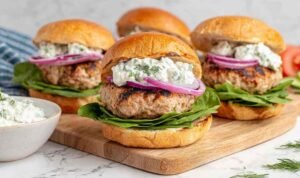 Juicy Greek turkey burgers topped with tzatziki, lettuce, and tomato on toasted buns