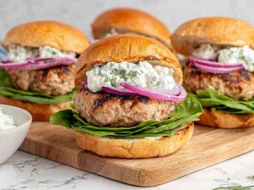 Juicy Greek turkey burgers topped with tzatziki, lettuce, and tomato on toasted buns