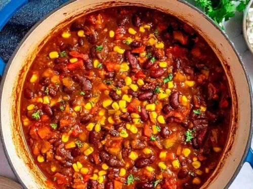 Bowl of homemade vegetarian chili topped with avocado slices and sour cream