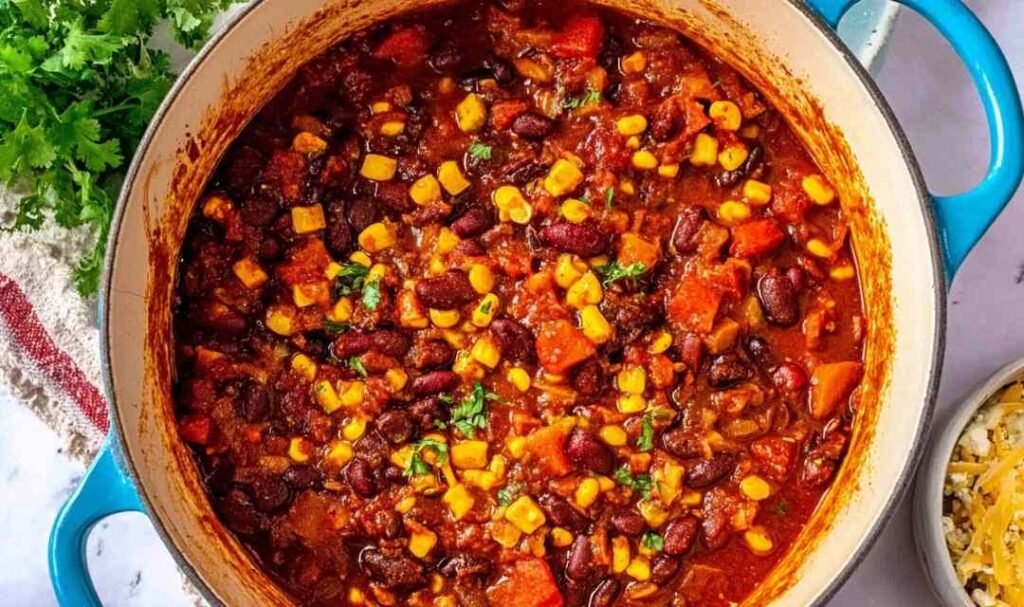 Bowl of homemade vegetarian chili topped with avocado slices and sour cream