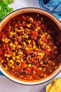 Bowl of homemade vegetarian chili topped with avocado slices and sour cream