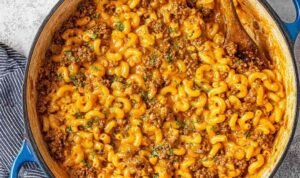 Homemade hamburger helper in a large pot with cheesy tomato sauce and seasoned ground beef