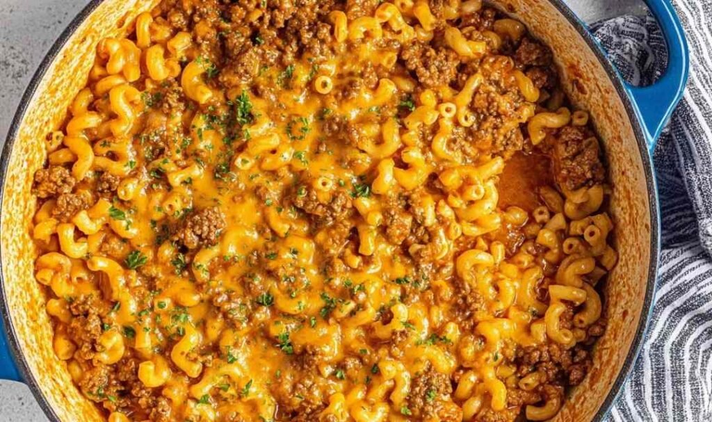 Homemade hamburger helper in a large pot with cheesy tomato sauce and seasoned ground beef