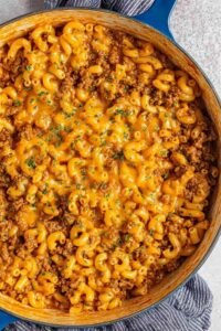 Homemade hamburger helper in a large pot with cheesy tomato sauce and seasoned ground beef