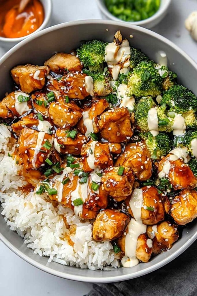 Hot Honey Chicken Bowl in a skillet with sticky honey glaze coating seared chicken, bell peppers, broccoli, and snap peas