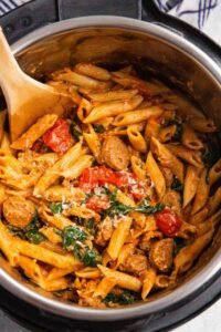 Instant Pot Pasta with Sausage with spinach and mozzarella stirred together in the pressure cooker pot