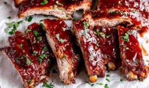 Fall-off-the-bone Instant Pot Ribs glazed with caramelized BBQ sauce on parchment paper